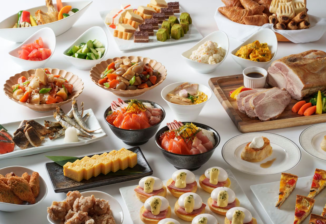 様々な料理が並べられたビュッフェスタイルの食卓。寿司、サラダ、肉料理、デザートなど多彩なメニューが用意されている。