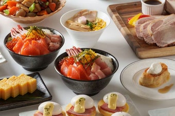 様々な料理が並べられたビュッフェスタイルの食卓。寿司、サラダ、肉料理、デザートなど多彩なメニューが用意されている。