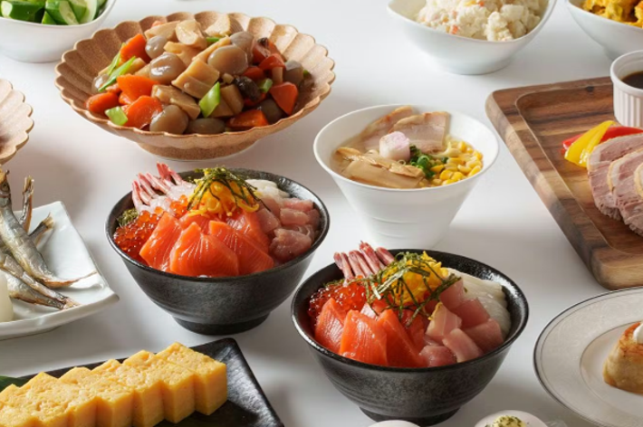様々な料理が並べられたビュッフェスタイルの食卓。寿司、サラダ、肉料理、デザートなど多彩なメニューが用意されている。