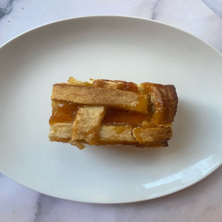 A slice of fruit pie with a lattice crust on a white plate