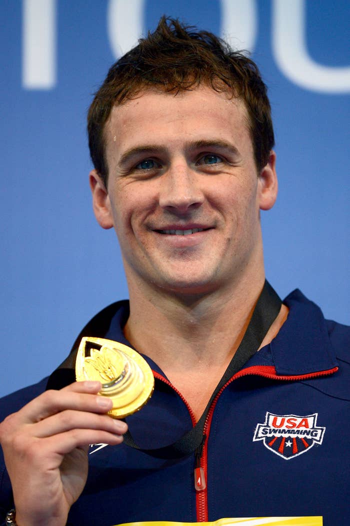 Person successful  USA Swimming overgarment   holds a golden  medal, smiling astatine  an event