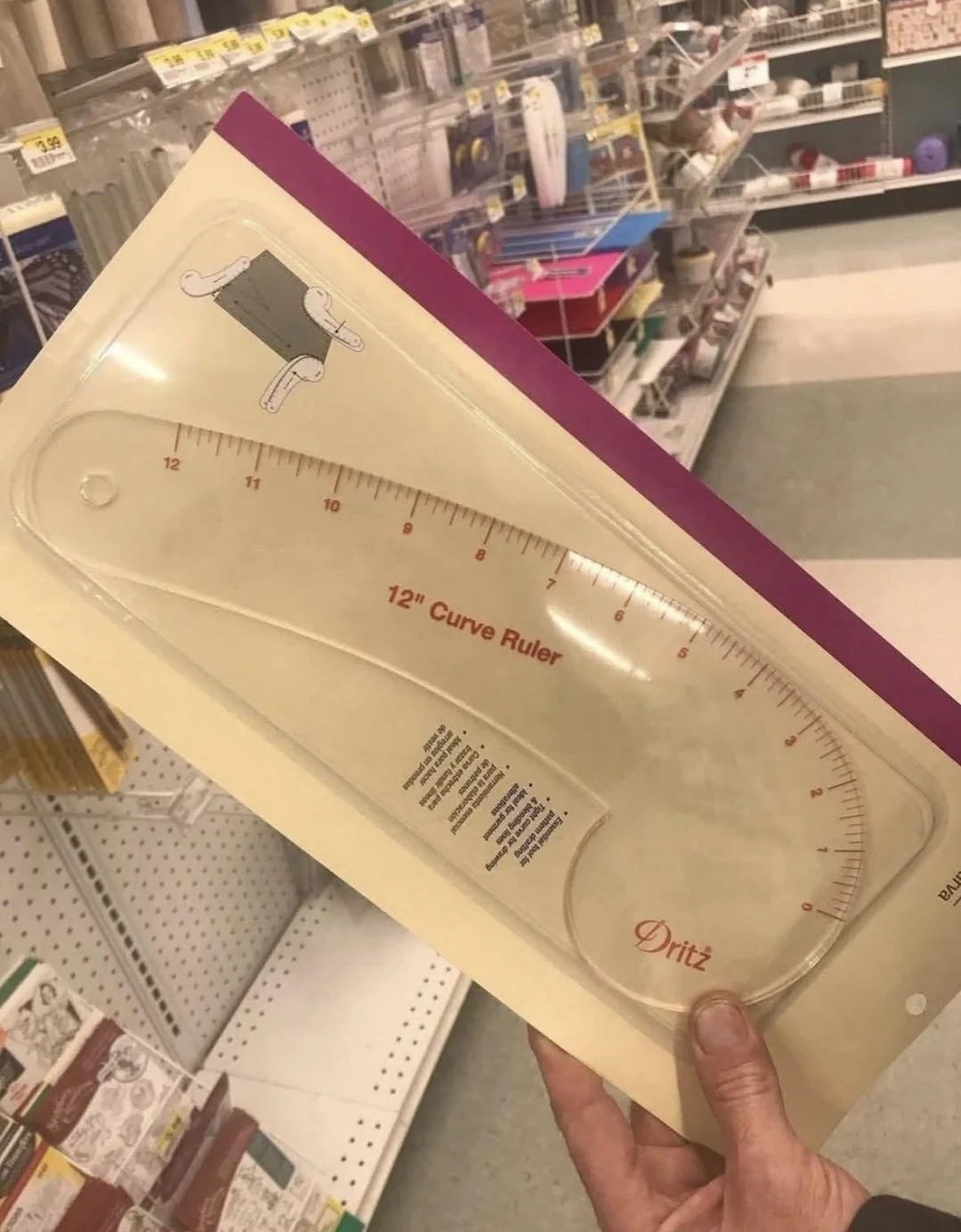 Person holding a 12-inch curve ruler successful  a store   aisle with assorted  crafting supplies successful  the background