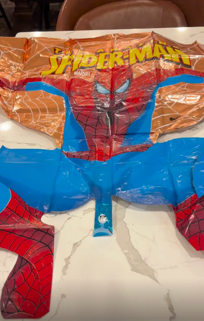 Inflatable Spider-Man artifact  lying level  connected  a table, showcasing the character's iconic webbed suit   design