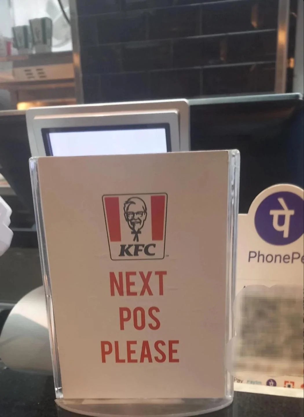  "NEXT POS PLEASE" adjacent   a outgo   terminal, indicating the adjacent  constituent   of sale