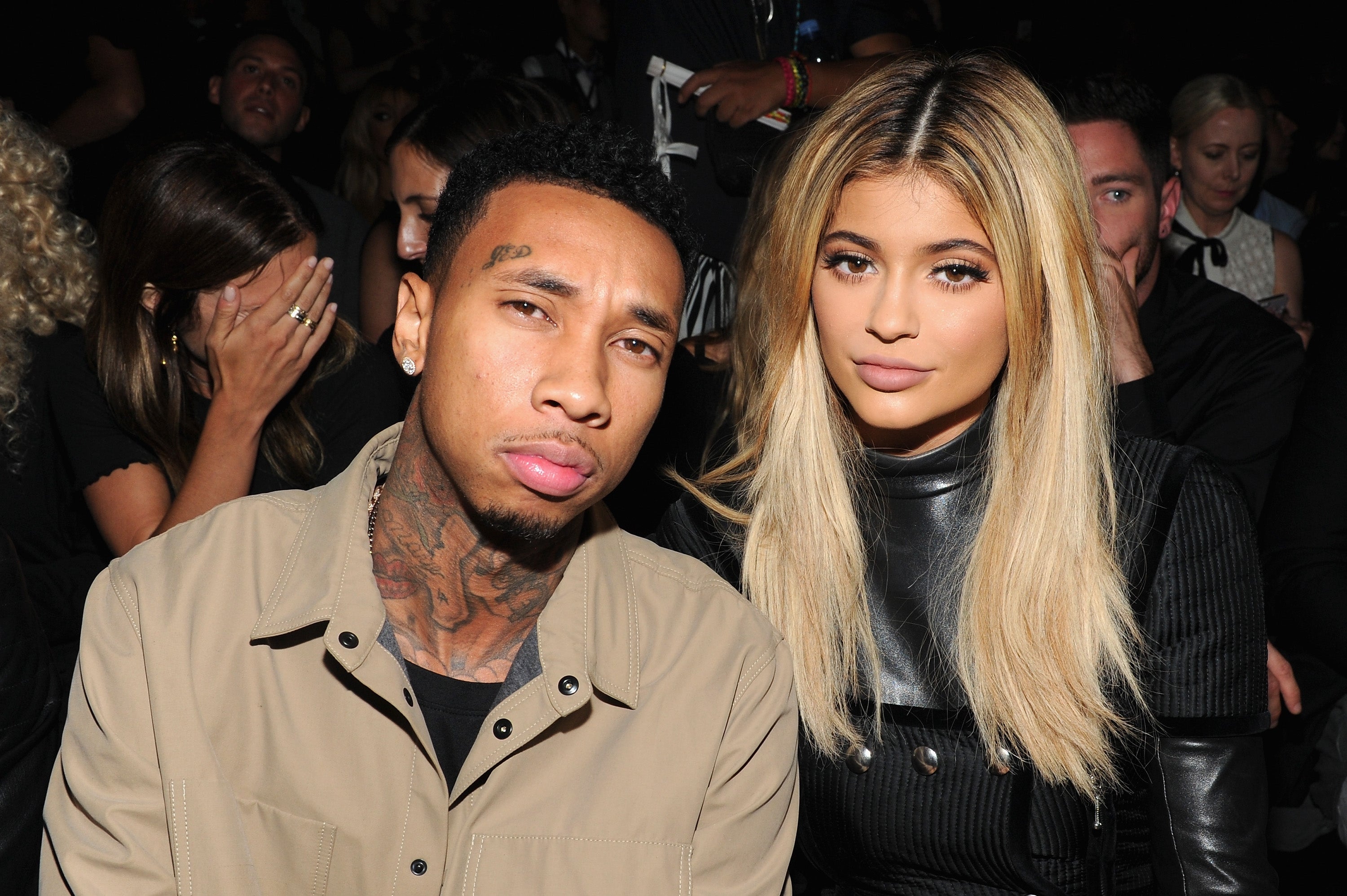 Two individuals are seated astatine an event, facing the camera. One wears a beige jacket, the different a achromatic outfit
