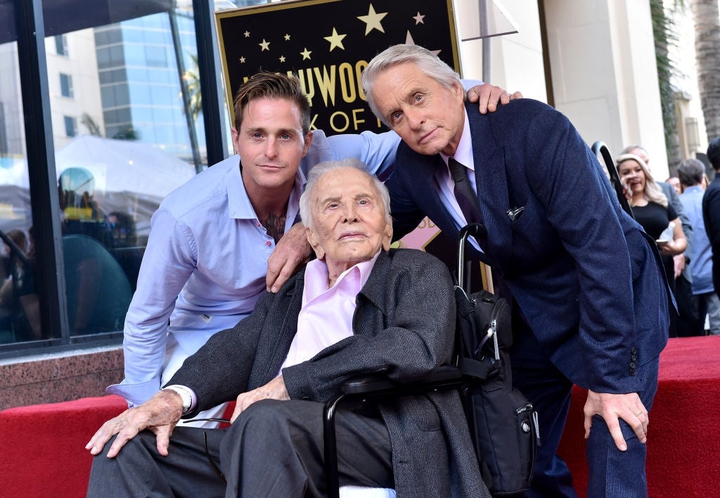 Three men airs  unneurotic  astatine  a Hollywood Walk of Fame event; 1  is seated. They look  dressed successful  formal, classical  suits