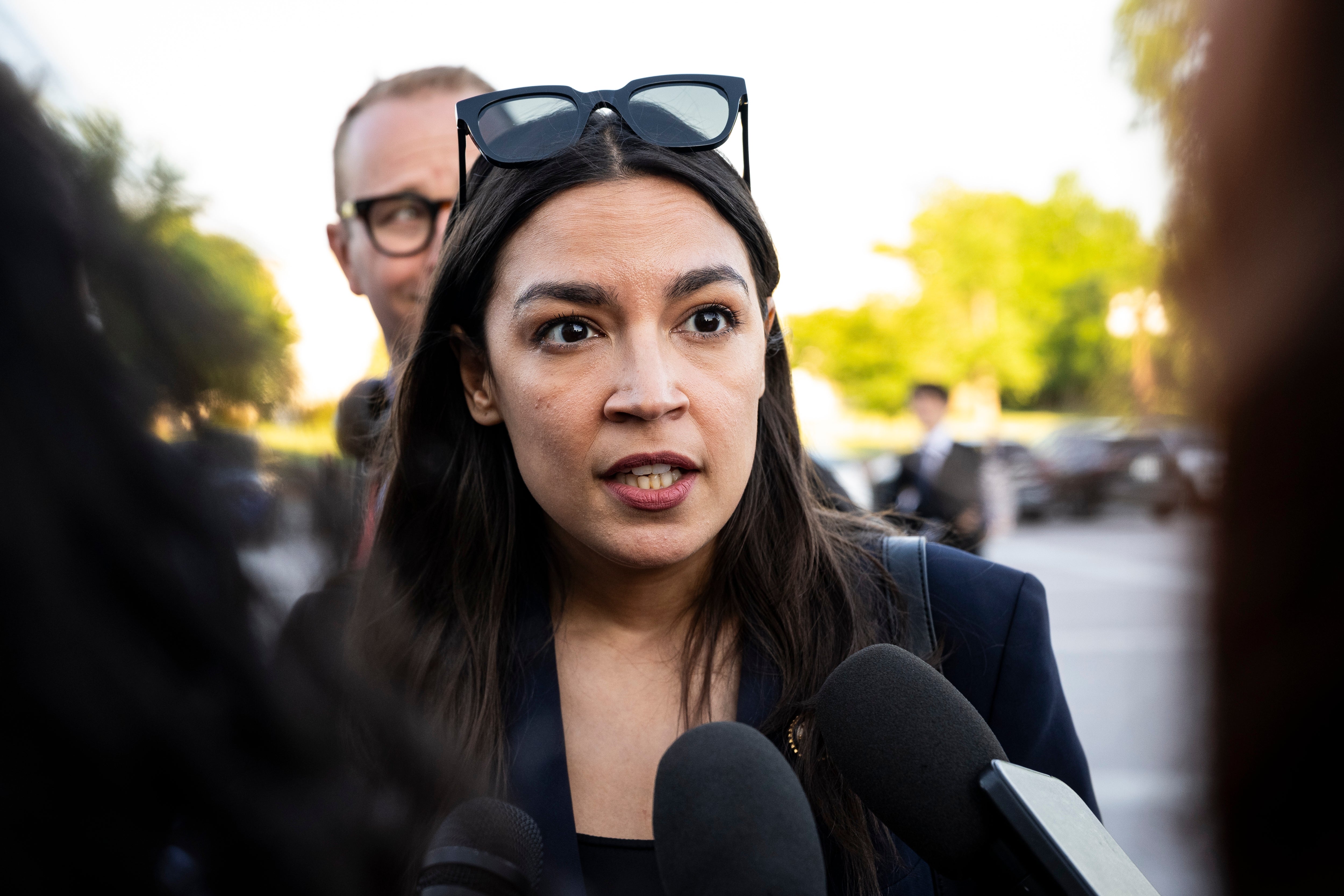 A idiosyncratic speaking to reporters, wearing sunglasses connected their head, with microphones successful the foreground