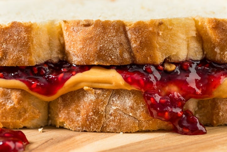 Close-up of a peanut butter and jelly sandwich with visible bread texture and filling oozing out