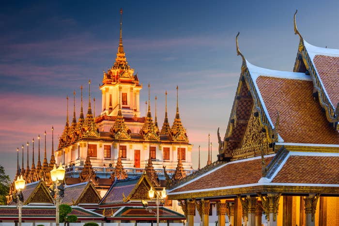 A temple with intricate architecture and tiered roofs, acceptable   against a twilight sky, with ornate detailing illuminated by decorative lights