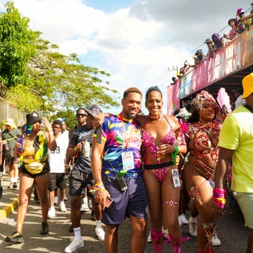 People celebrating at a street festival, wearing vibrant costumes with feathers and beads