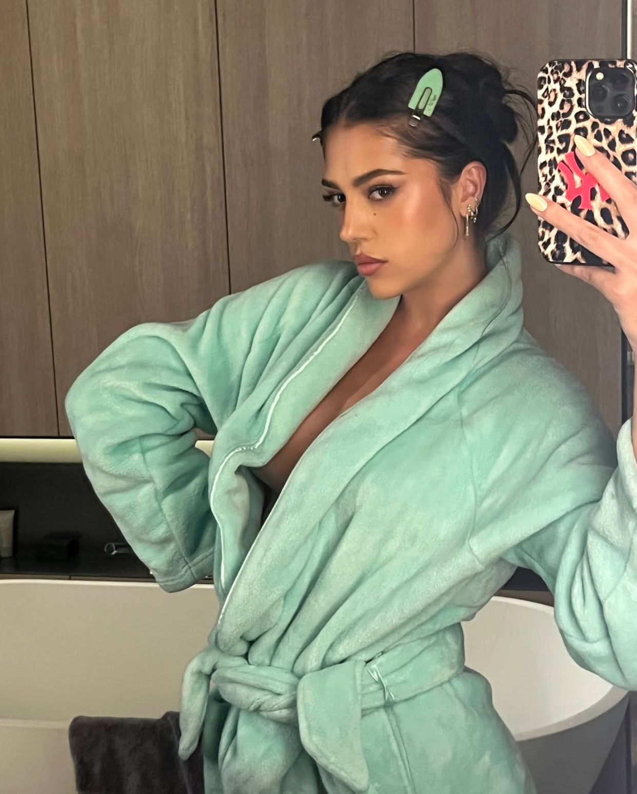Person successful  a plush robe taking a reflector  selfie, with hairsbreadth  clips and a telephone  lawsuit  with a leopard people     pattern
