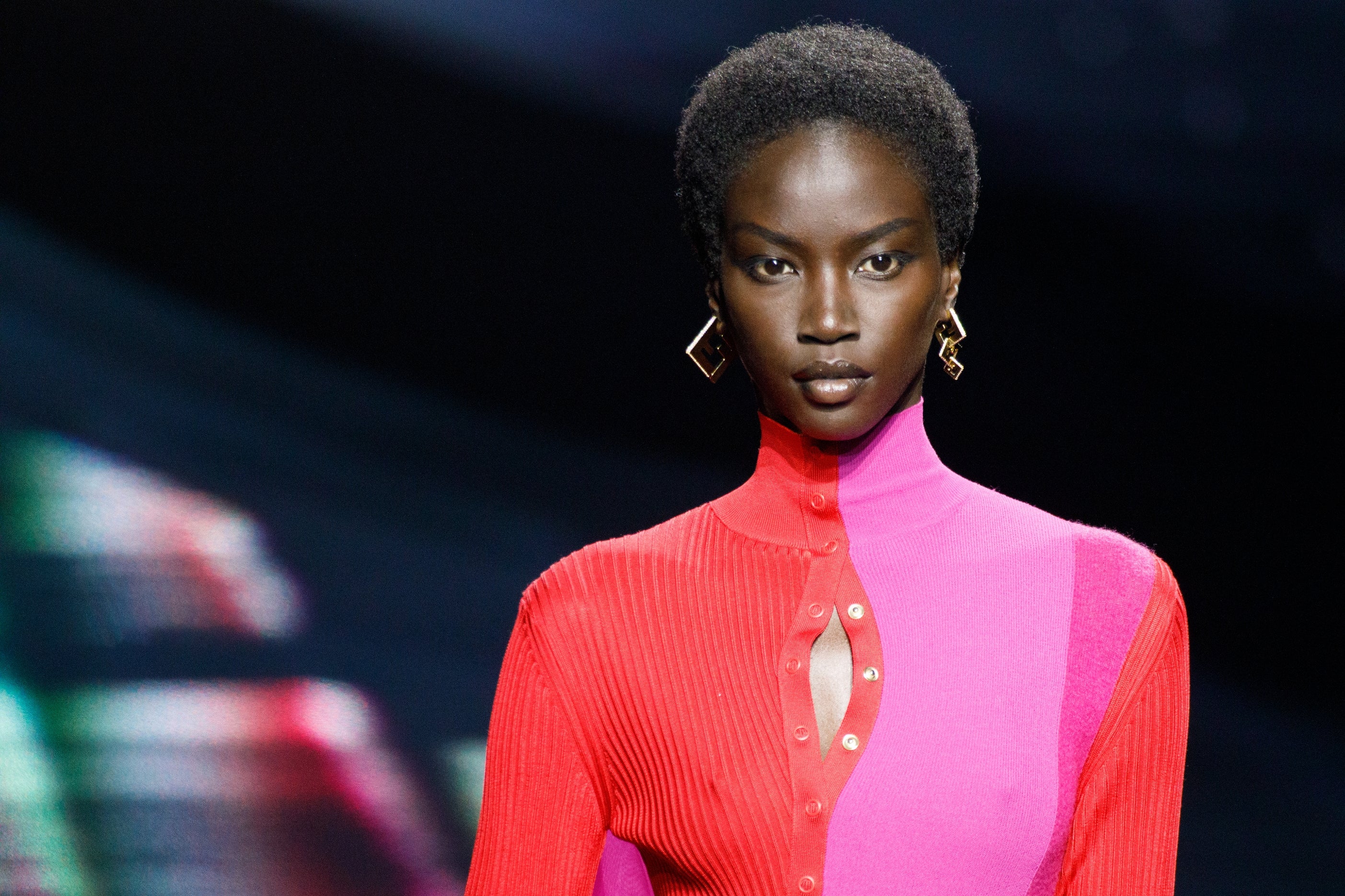 Model successful  chic, color-blocked outfit with geometric earrings, connected  the runway