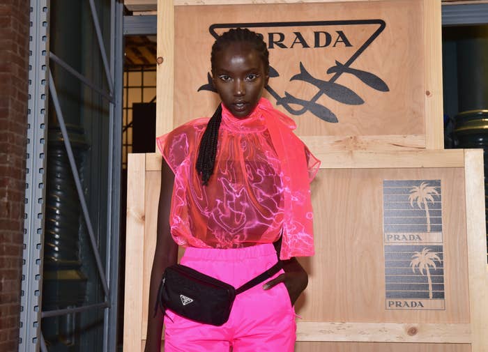 Model poses successful  a sheer, neon patterned apical  and matching vibrant pants astatine  a Prada event