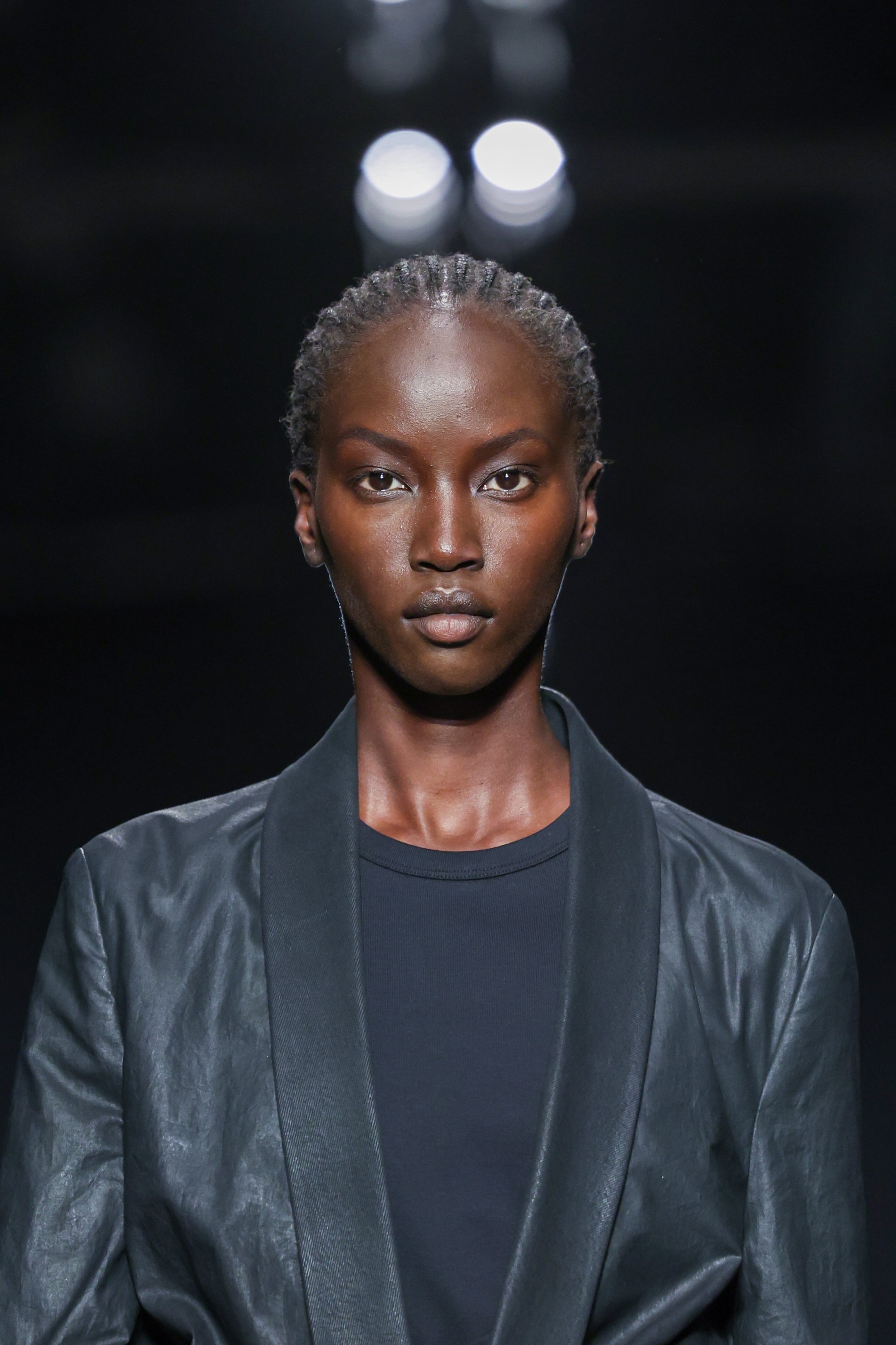 A idiosyncratic   connected  a runway wears a tailored, sleek leather overgarment   implicit    a acheronian  shirt, exuding a assured  and poised presence