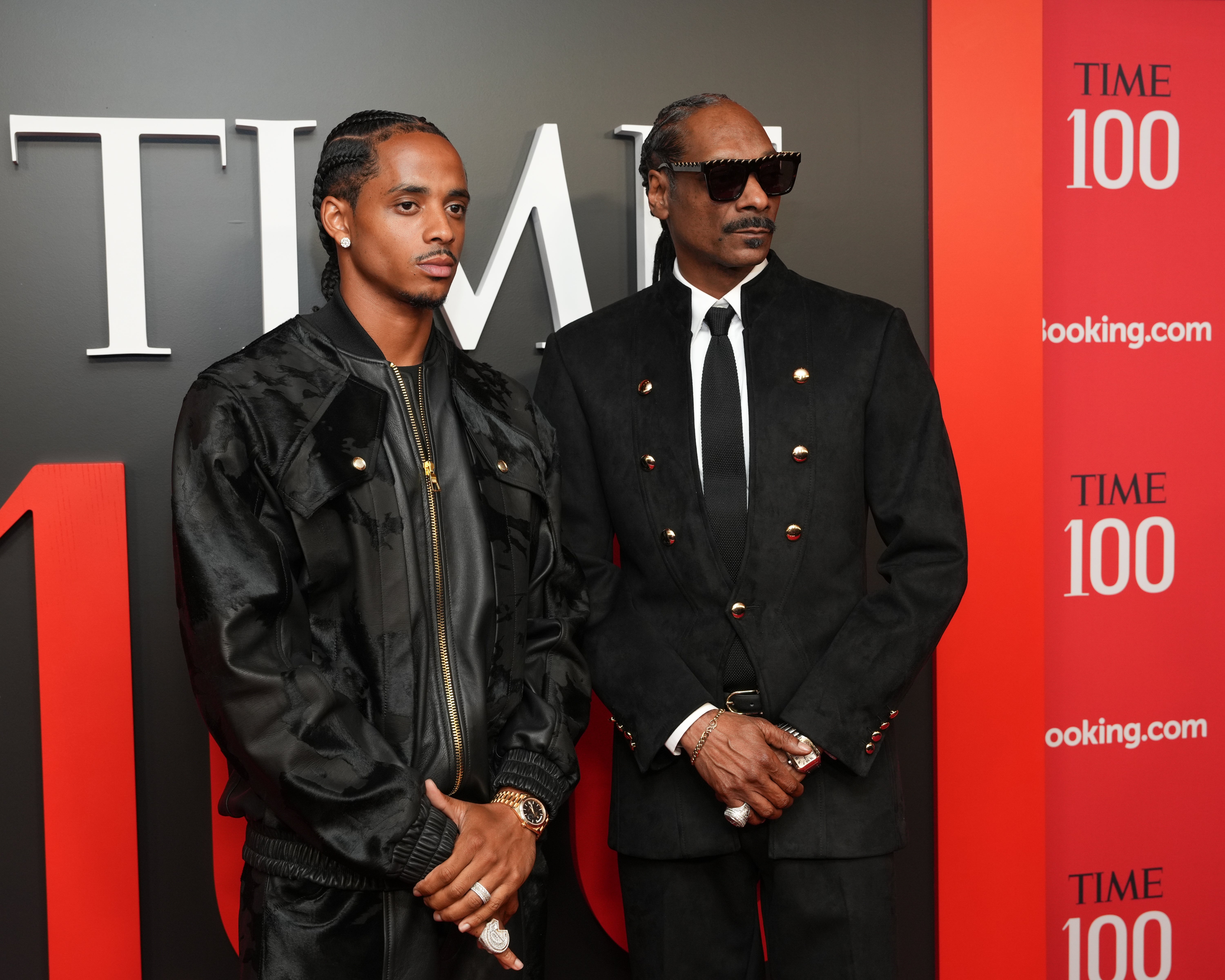 Two men connected  a reddish  carpet astatine  a TIME 100 event, wearing stylish achromatic  suits, posing for photos