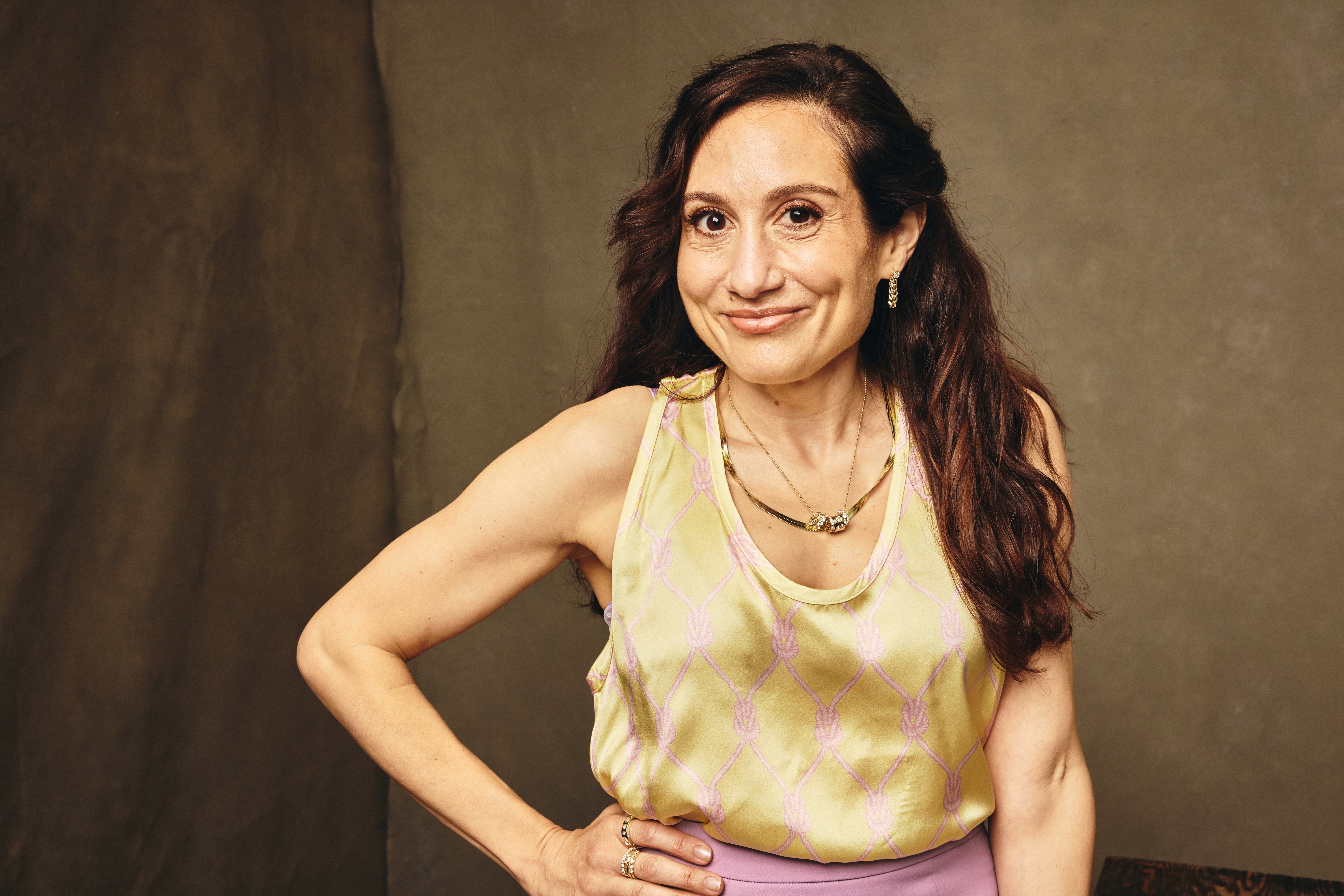 Person posing confidently successful  a workplace  setting, wearing a sleeveless apical  and necklace