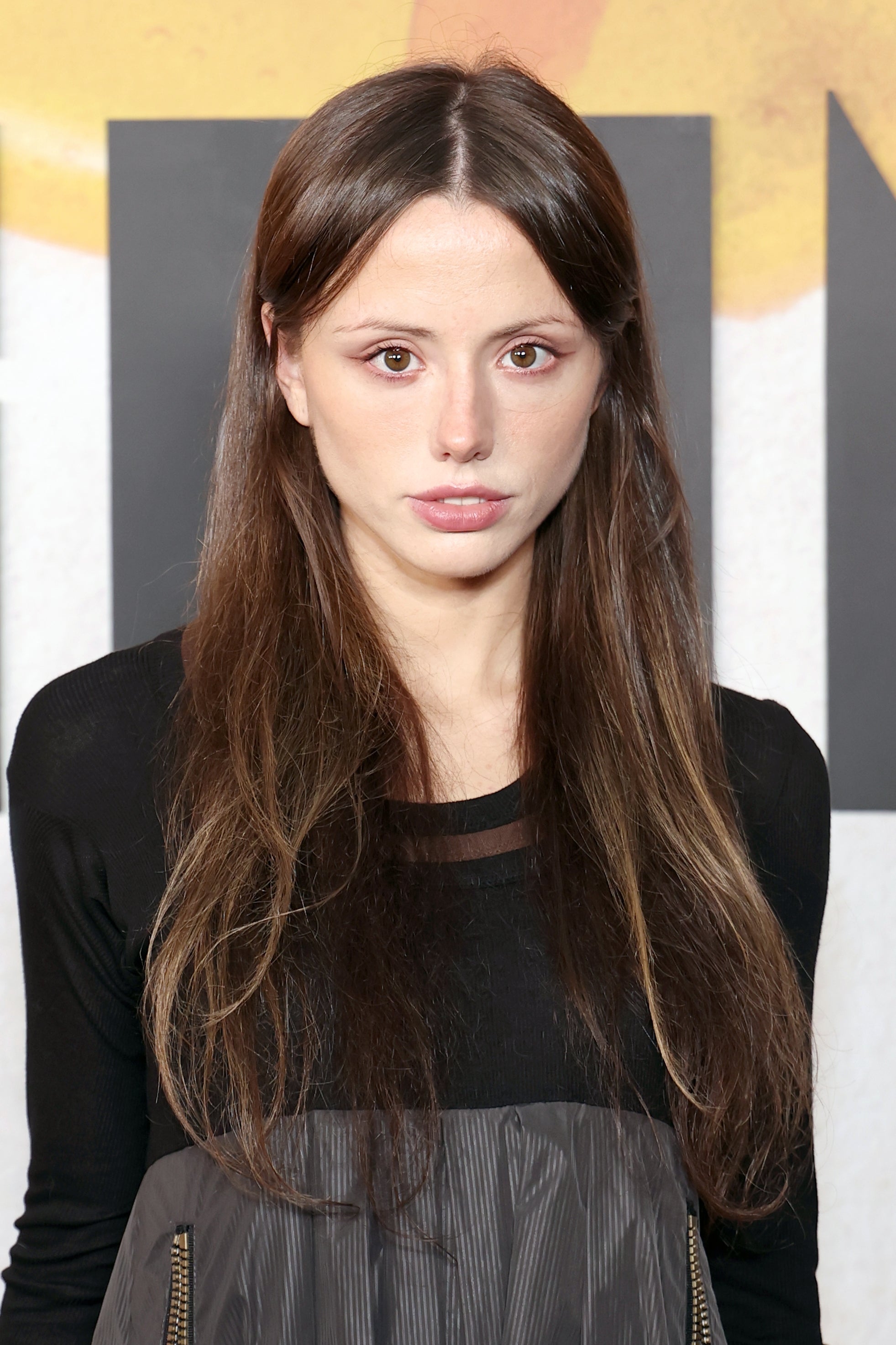 Person successful  fashion-forward outfit with agelong  hairsbreadth  stands astatine  an event