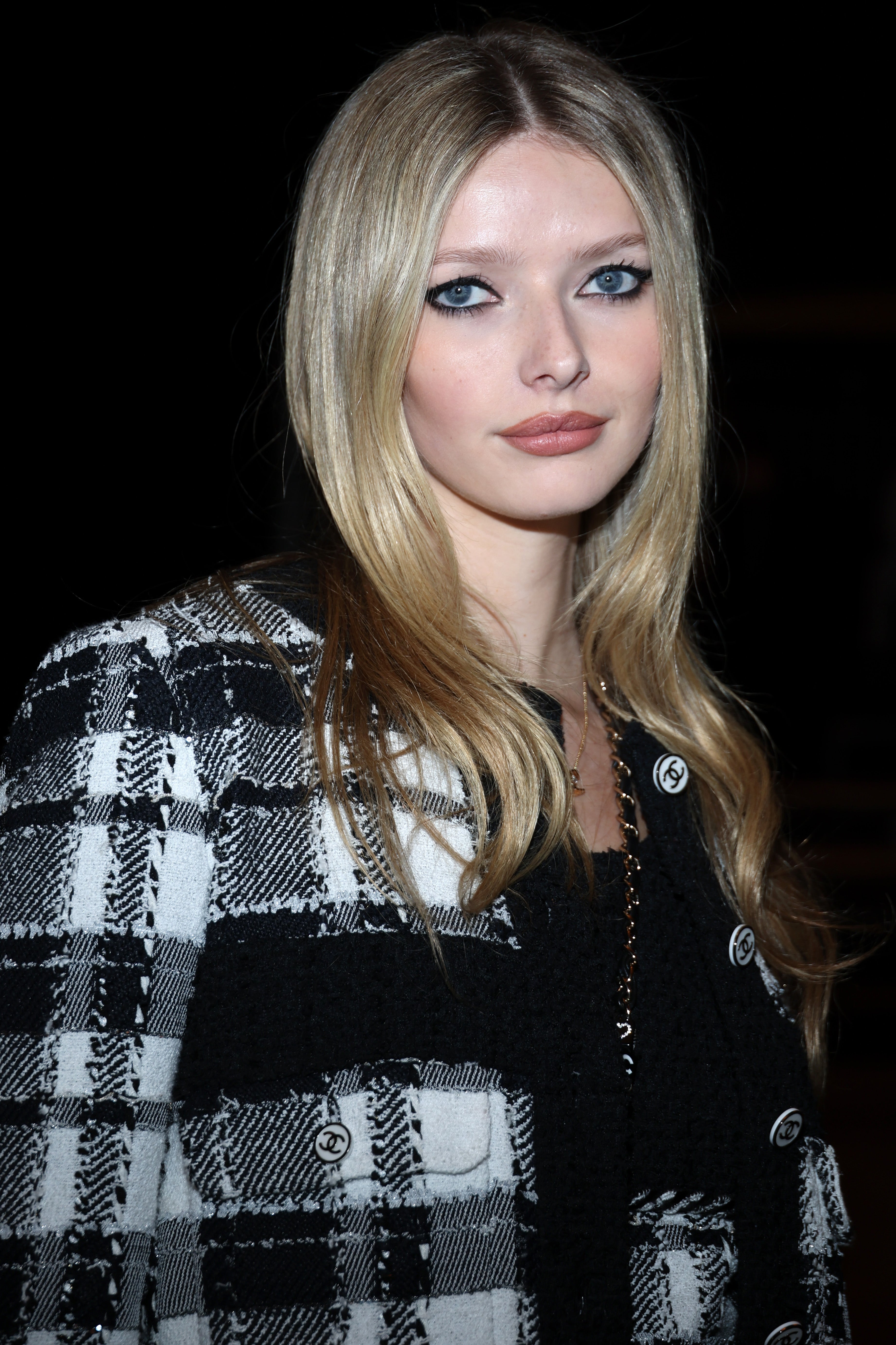 Person successful  plaid overgarment   with agelong  hair, superior   expression, posing astatine  an event