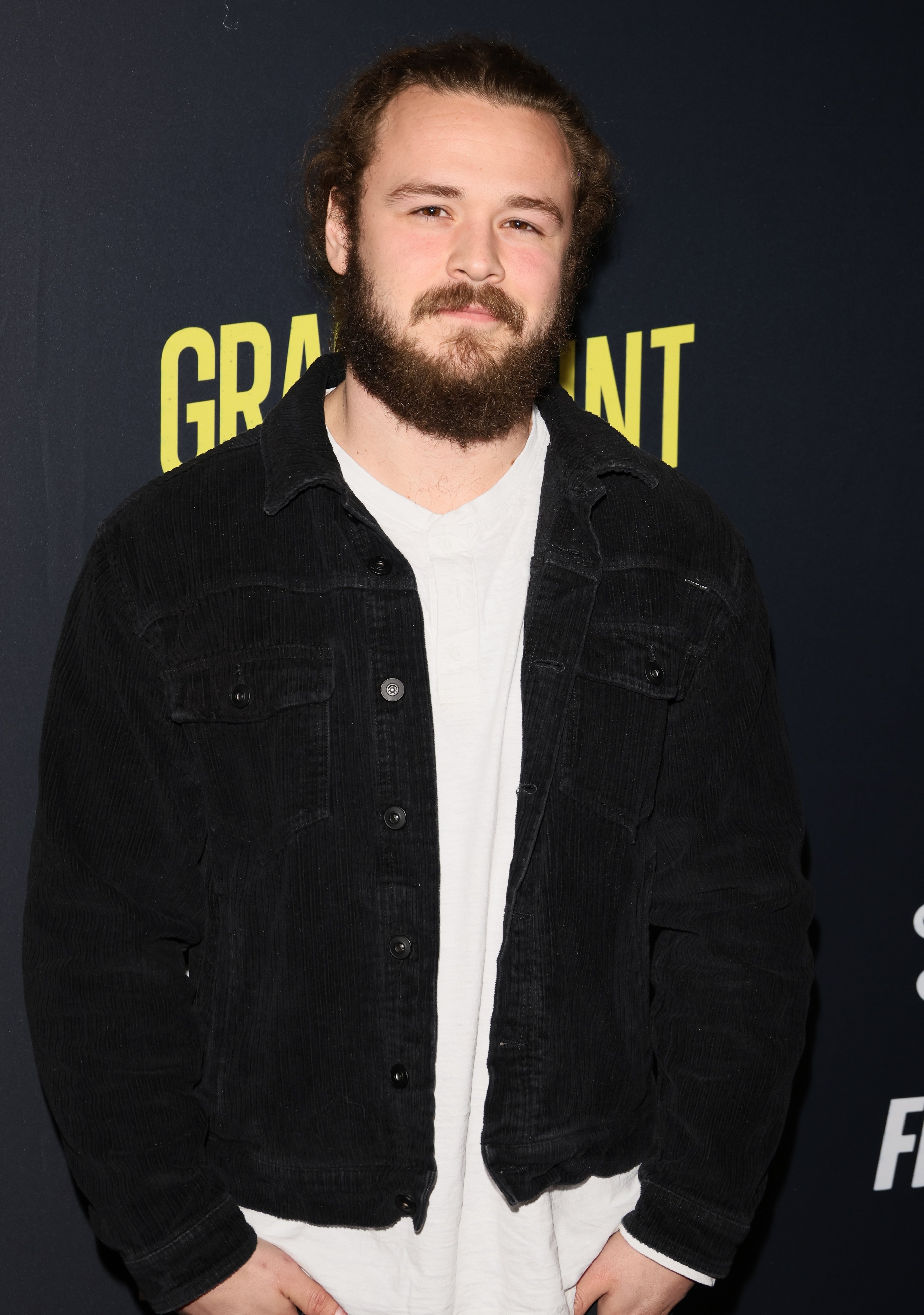 Person connected  a reddish  carpet wearing a casual achromatic  overgarment   implicit    a achromatic  t-shirt astatine  a personage  event