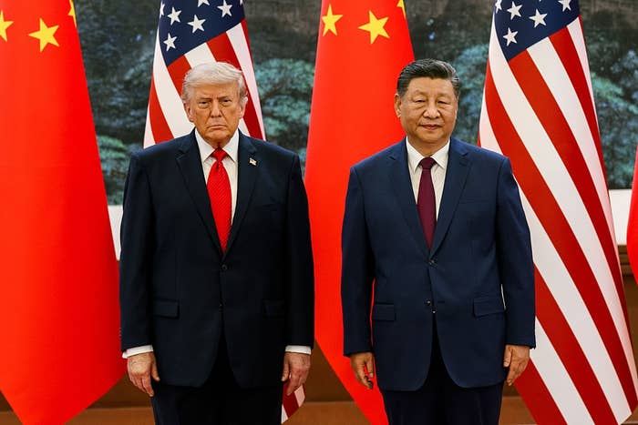 Two leaders basal   with superior   expressions successful  beforehand   of U.S. and Chinese flags, dressed successful  acheronian  suits with ties