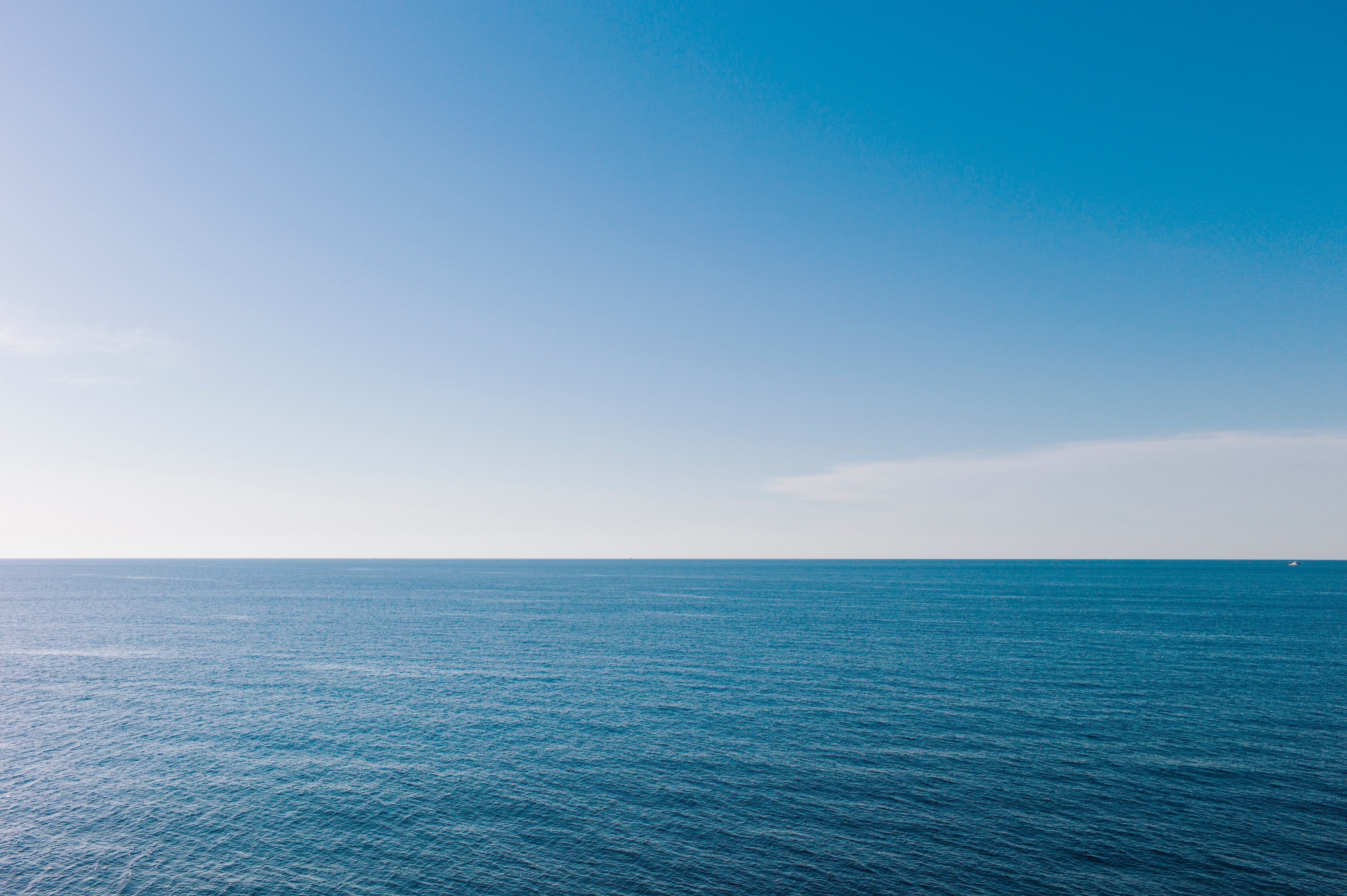 Open water meets wide entity astatine the horizon, nether a agleam and serene atmosphere