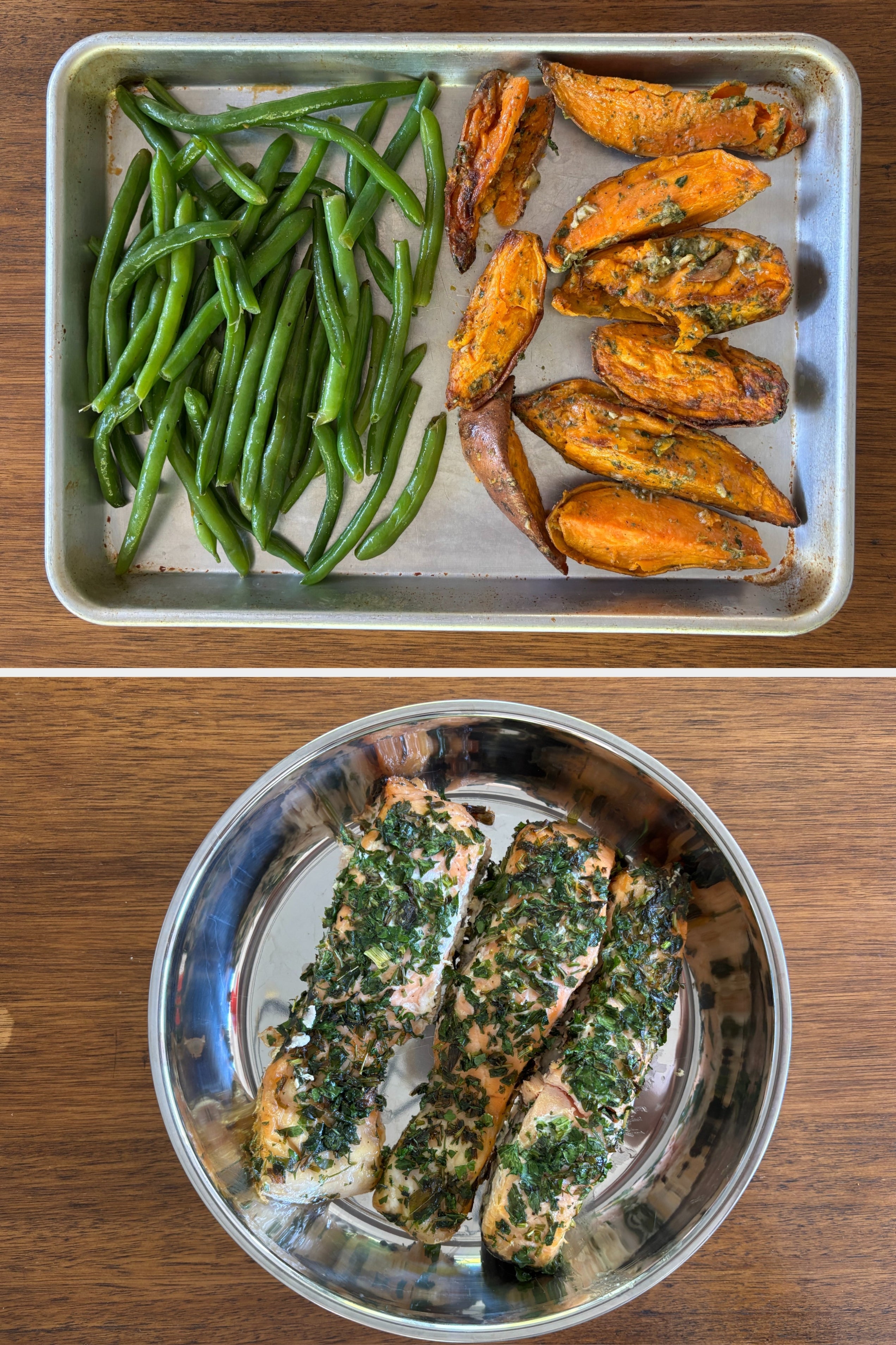 Three herb-crusted salmon fillets in a metal dish on a wooden table