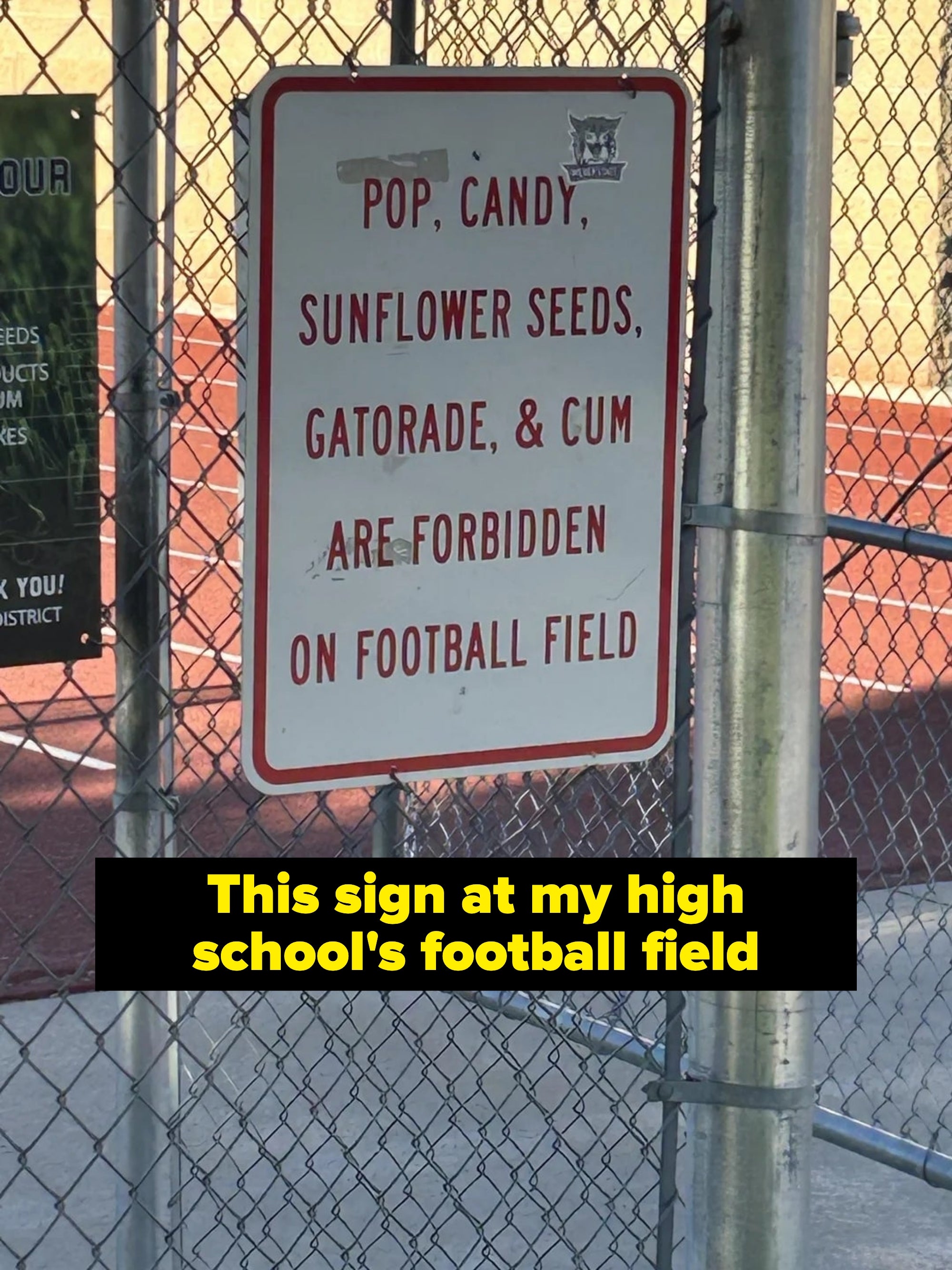 Sign on fence listing items prohibited on football field: pop, candy, sunflower seeds, Gatorade, and gum