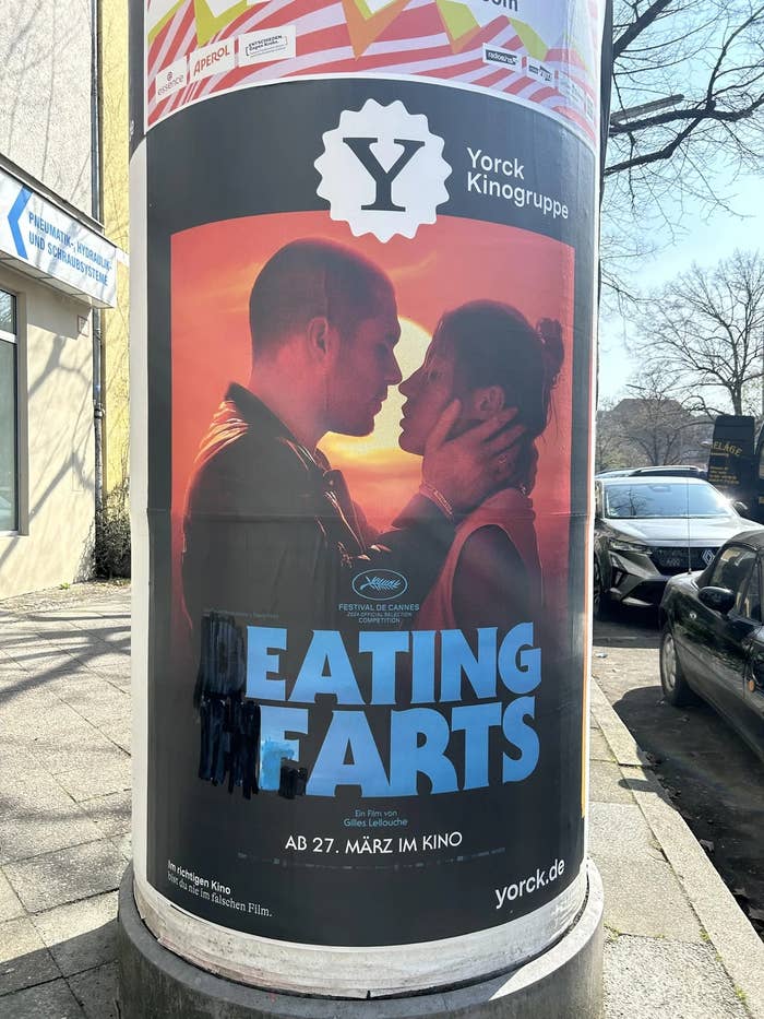 Movie poster on a street pillar featuring a couple about to kiss. The title "Beating Hearts" is partially obscured