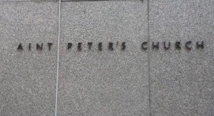 Sign with text "Saint Peter's Church" on a textured stone wall