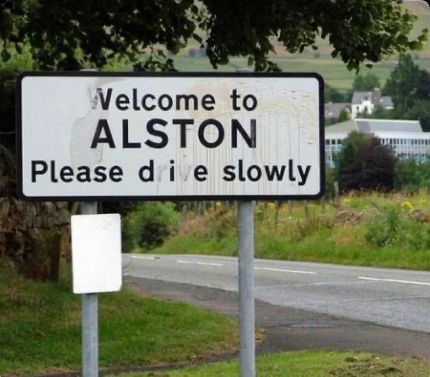 Road sign reads: "Welcome to Alston. Please drive slowly," with part of the 'r' missing