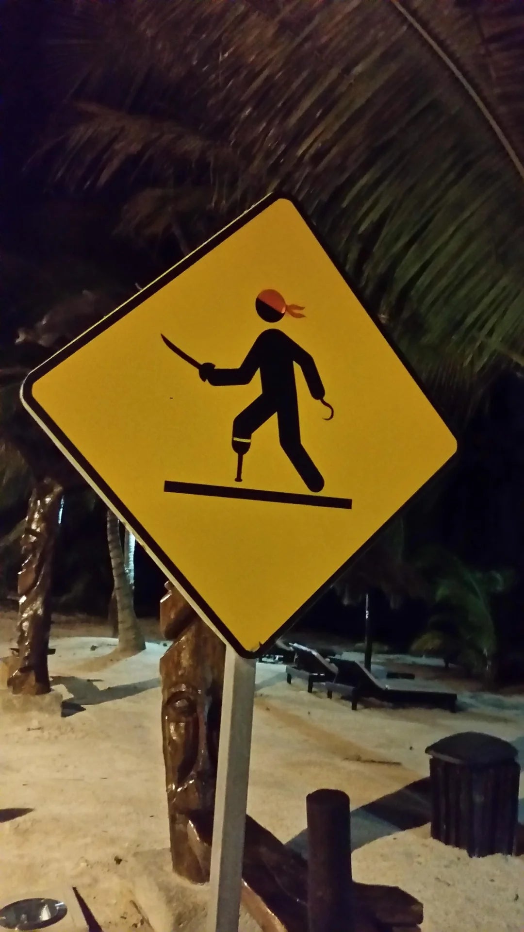 Pirate-themed warning sign showing a stick figure with a hook, peg leg, and bandana