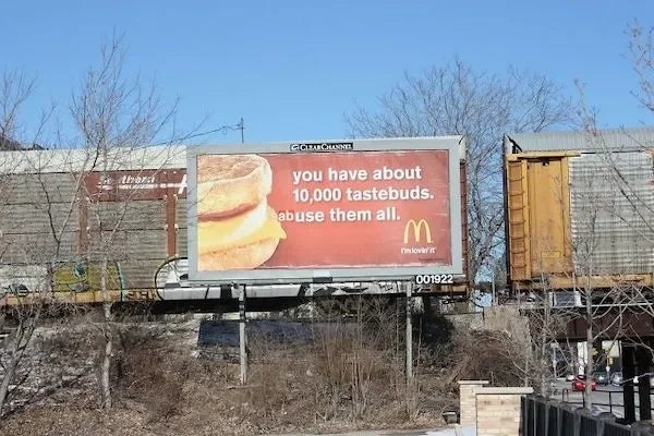 McDonald's billboard with two breakfast sandwiches and text: "You have about 10,000 tastebuds. Abuse them all."
