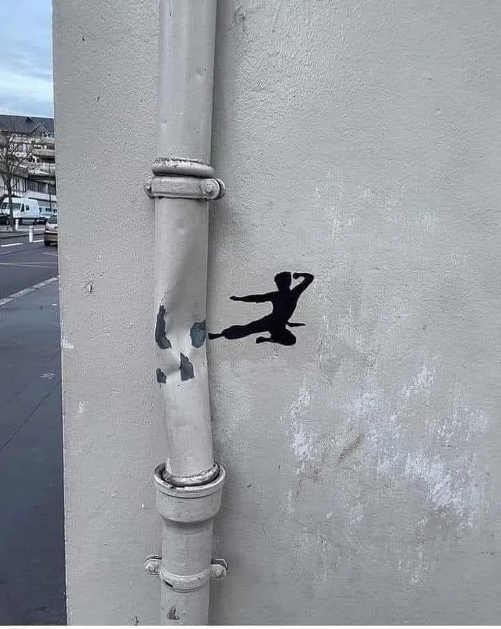 Silhouette of a martial artist appears to kick a pipe, creating an illusion of interaction with the wall