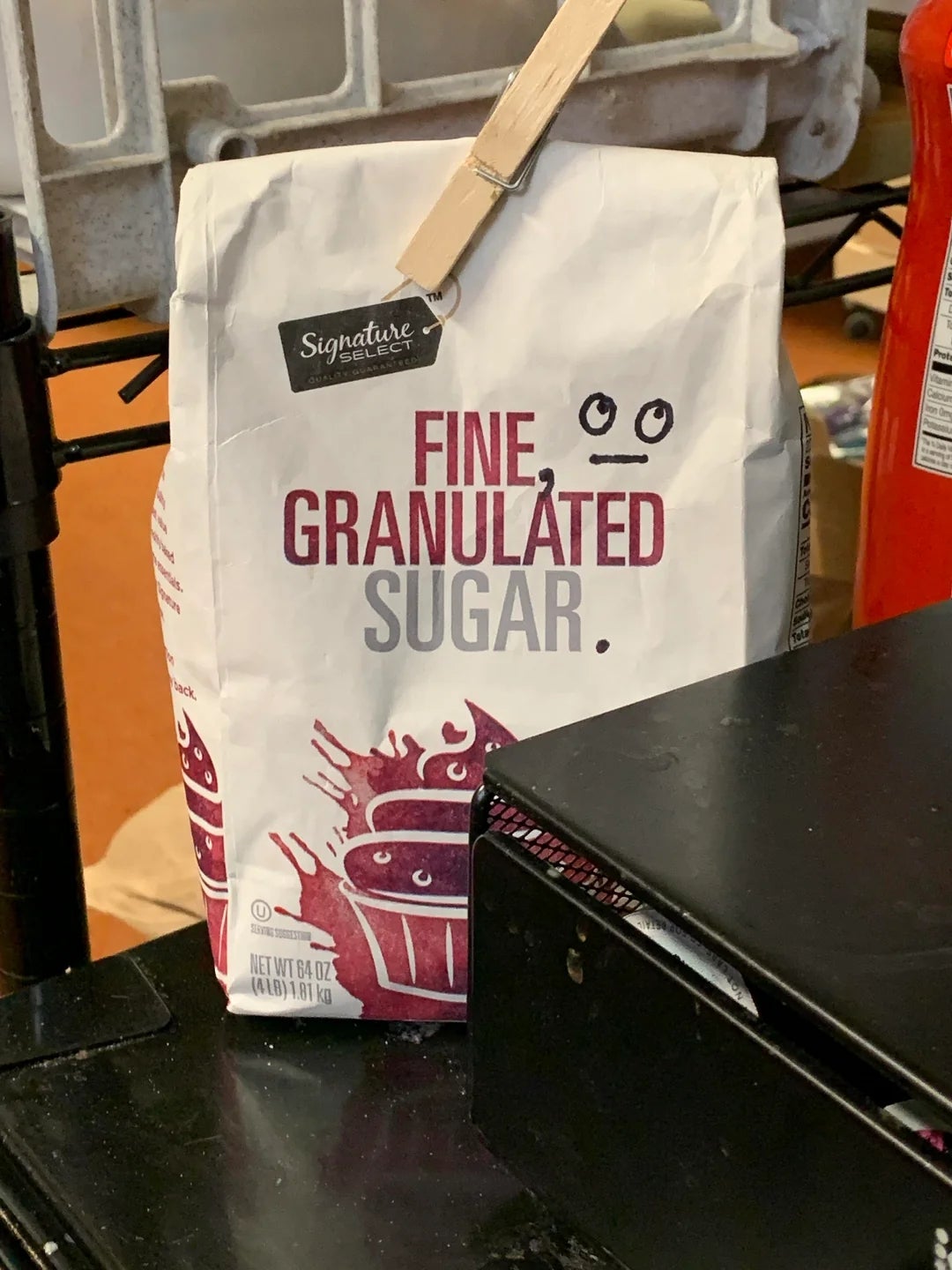 Bag of fine granulated sugar with a clip on top, placed on a counter