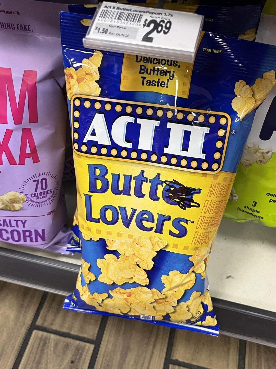 A bag of ACT II Butter Lovers microwave popcorn on a store shelf, priced at $2.69