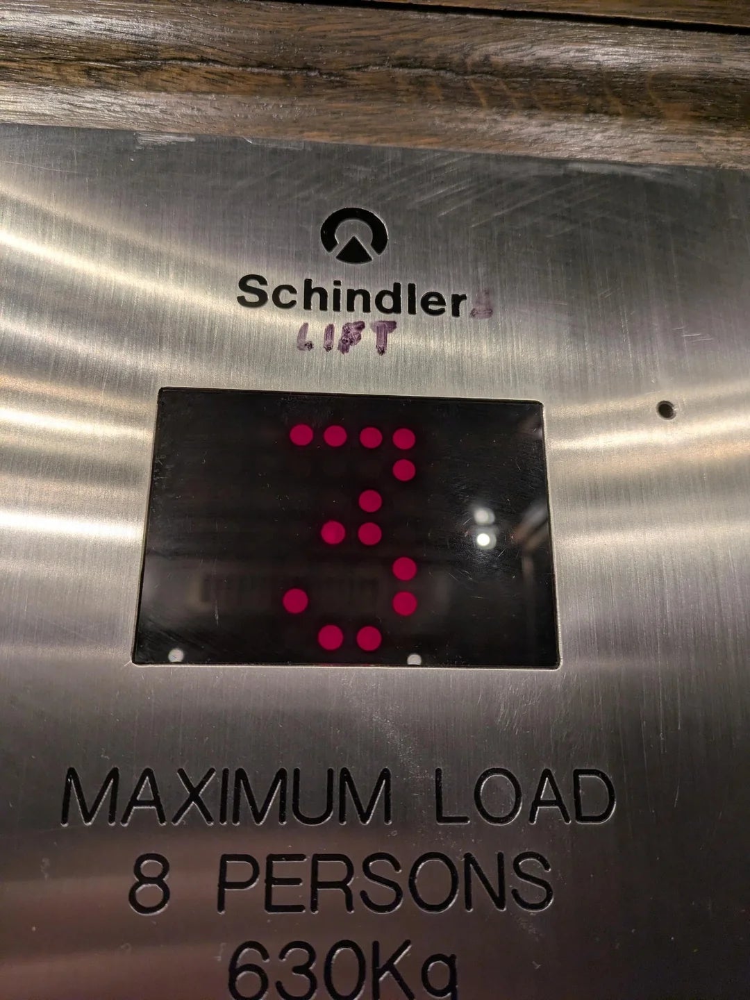 Elevator panel showing the number 3 for the current floor. Maximum load is 8 persons or 630 kg