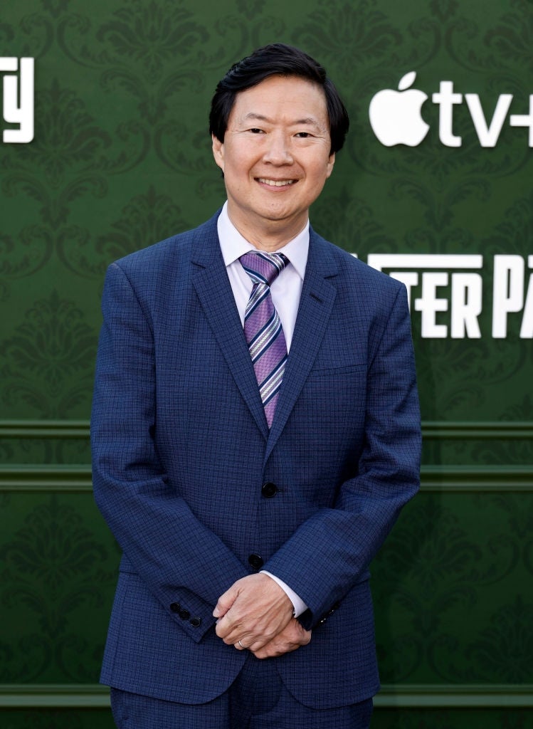 Person successful  a suit   with a striped tie, lasting  successful  beforehand   of an Apple TV+ lawsuit   backdrop