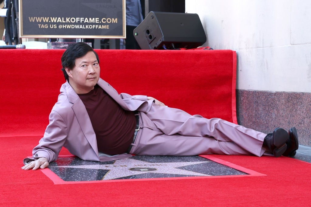 Actor posing casually connected  the Hollywood Walk of Fame, reclining connected  his star, dressed successful  a stylish suit