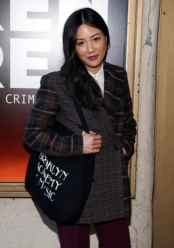 Person successful  plaid overgarment  with a Brooklyn Academy of Music tote bag, lasting  successful  beforehand   of a poster
