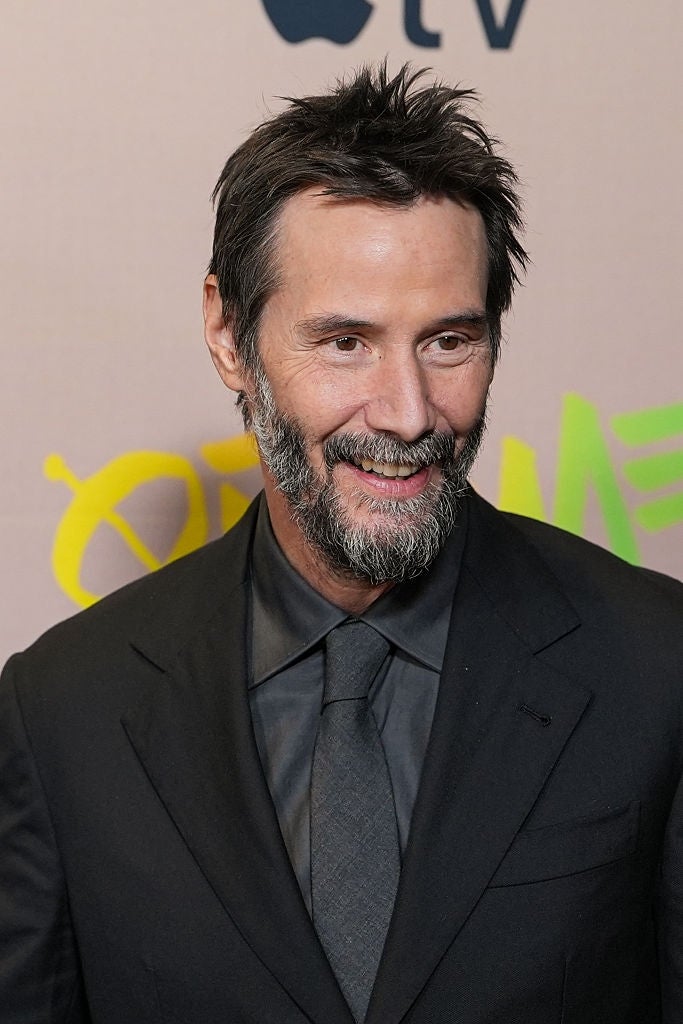 Person successful  a ceremonial  suit   and tie, smiling astatine  an event