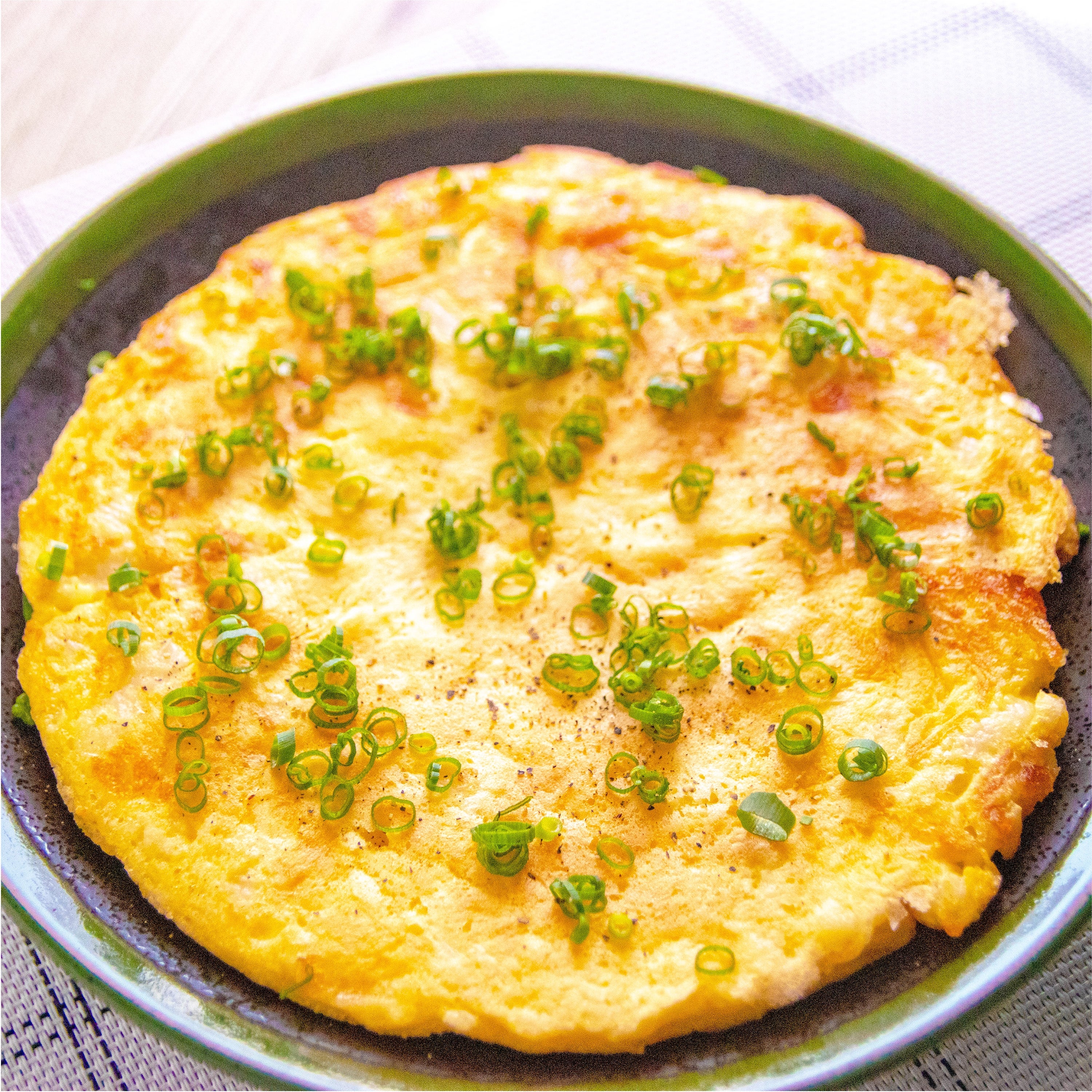 長芋チーズ焼きが皿に盛られ、美しくネギが散らされています。