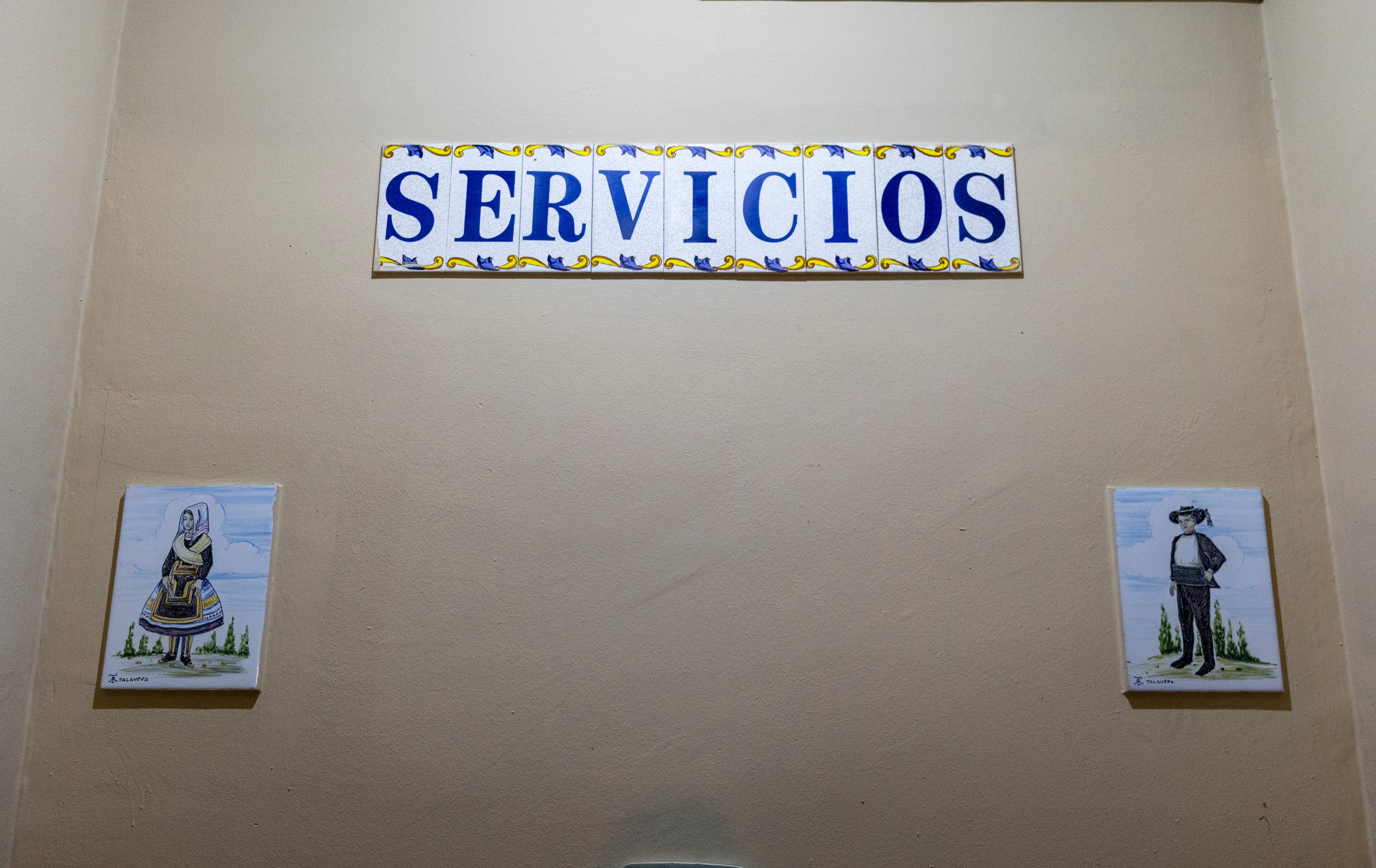 Sign with "Servicios" supra 2 illustrated restroom signs, depicting accepted figures for men and women
