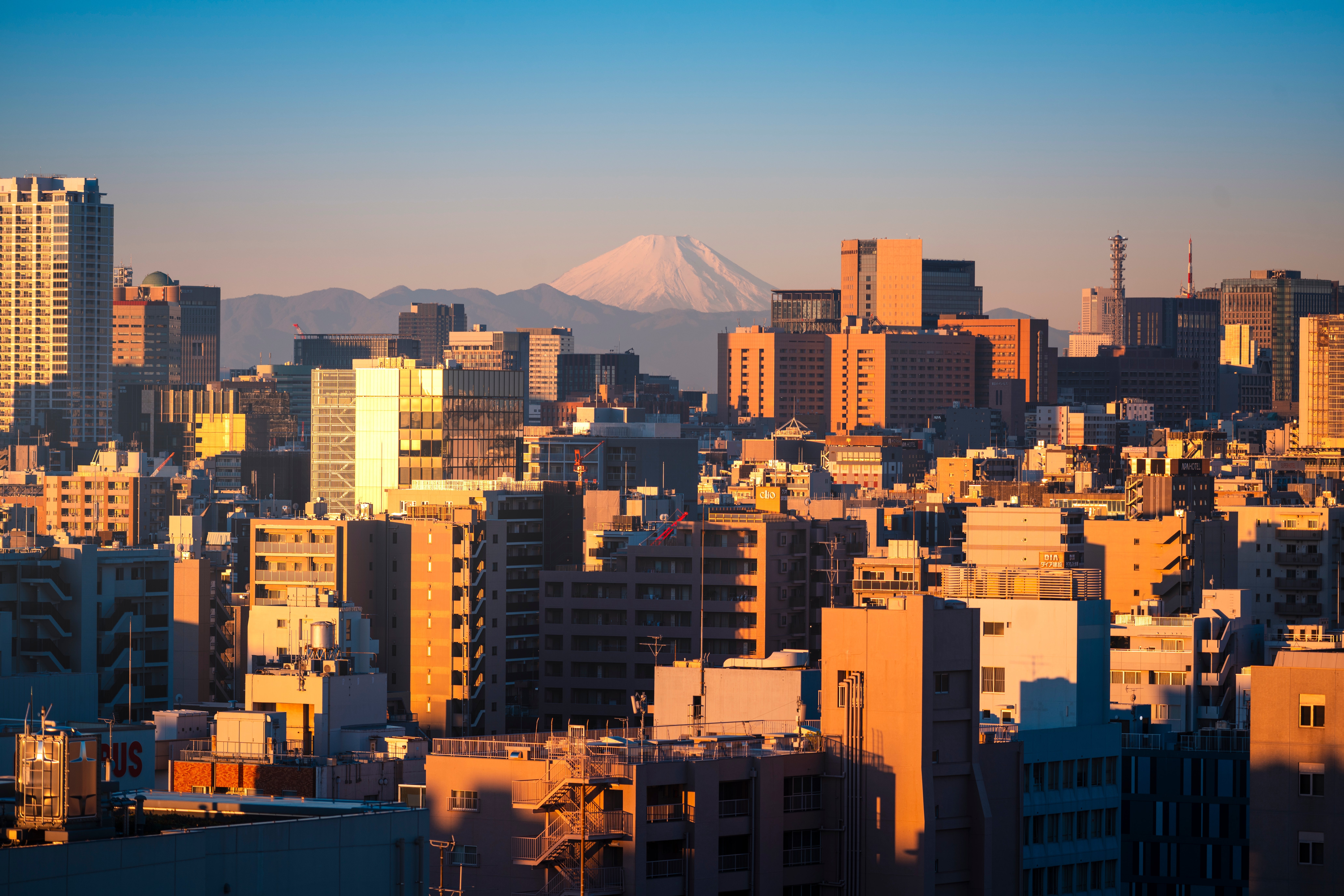 City skyline with buildings astatine sunrise, Mount Fuji disposable successful the inheritance nether a wide sky