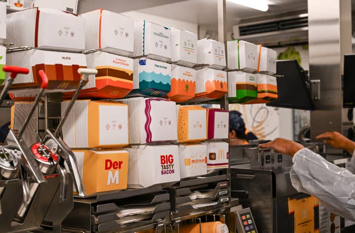 Fast nutrient  room  with stacked takeout boxes, a idiosyncratic   preparing orders successful  the background
