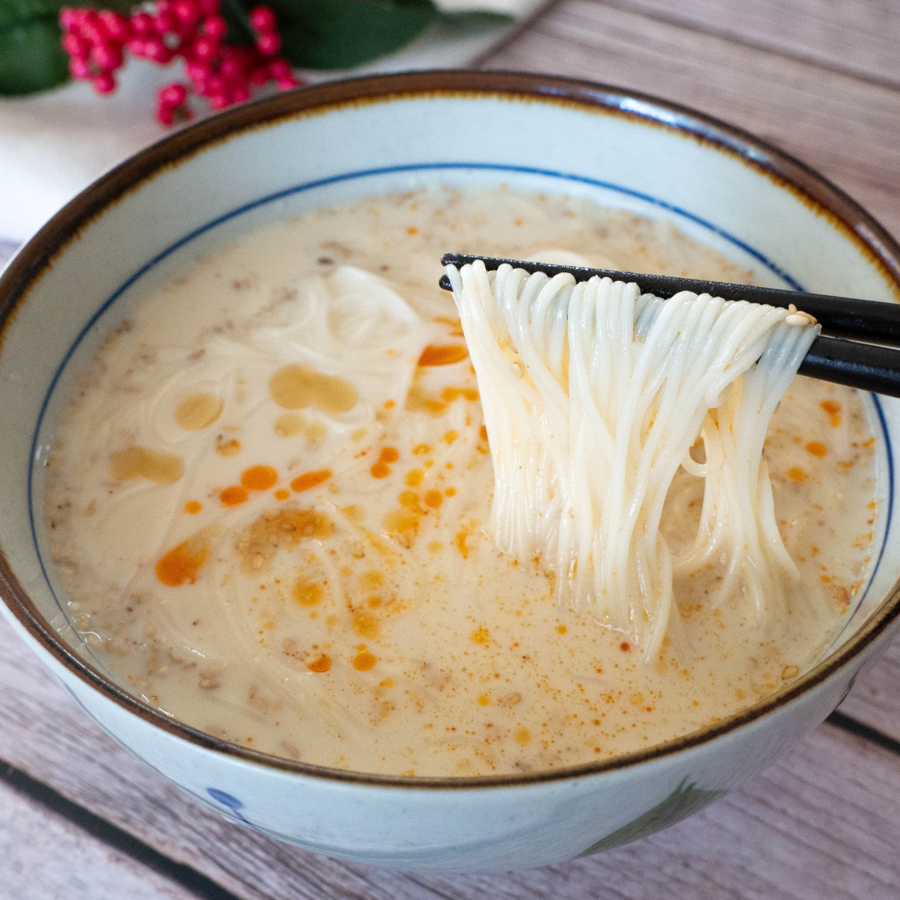 箸で持ち上げられたごまみそ豆乳そうめん。