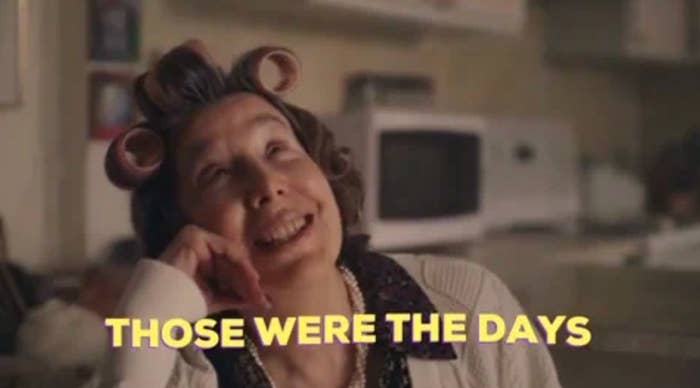 Person with curlers, smiling nostalgically in a kitchen setting. Text on image: "THOSE WERE THE DAYS."