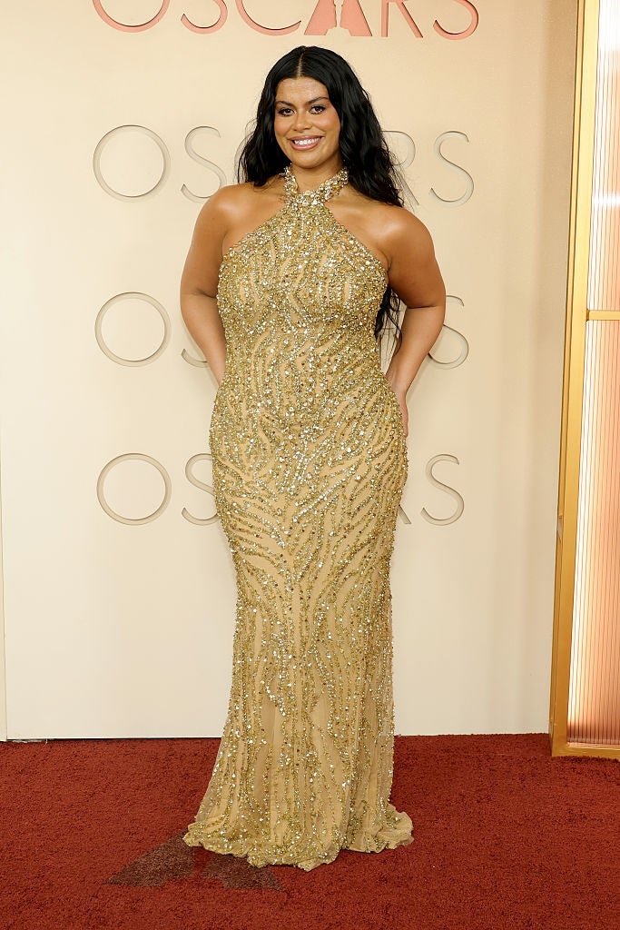 Person successful  an elegant, sequined gown poses connected  a reddish  carpet astatine  a personage  event