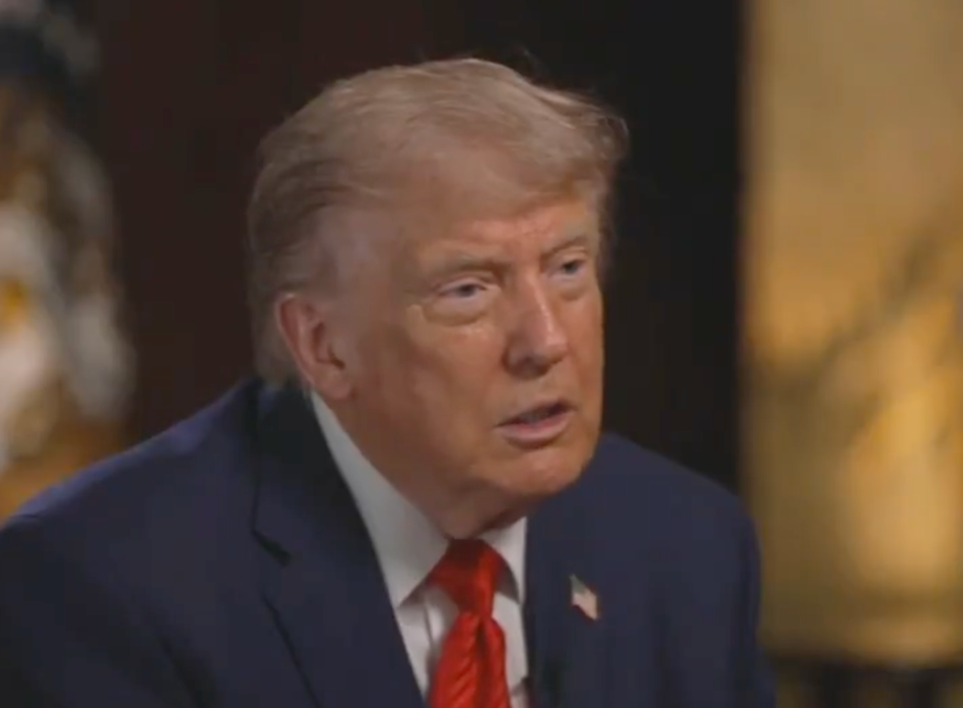 A idiosyncratic   successful  a suit   and reddish  necktie  is speaking successful  an interrogation  setting