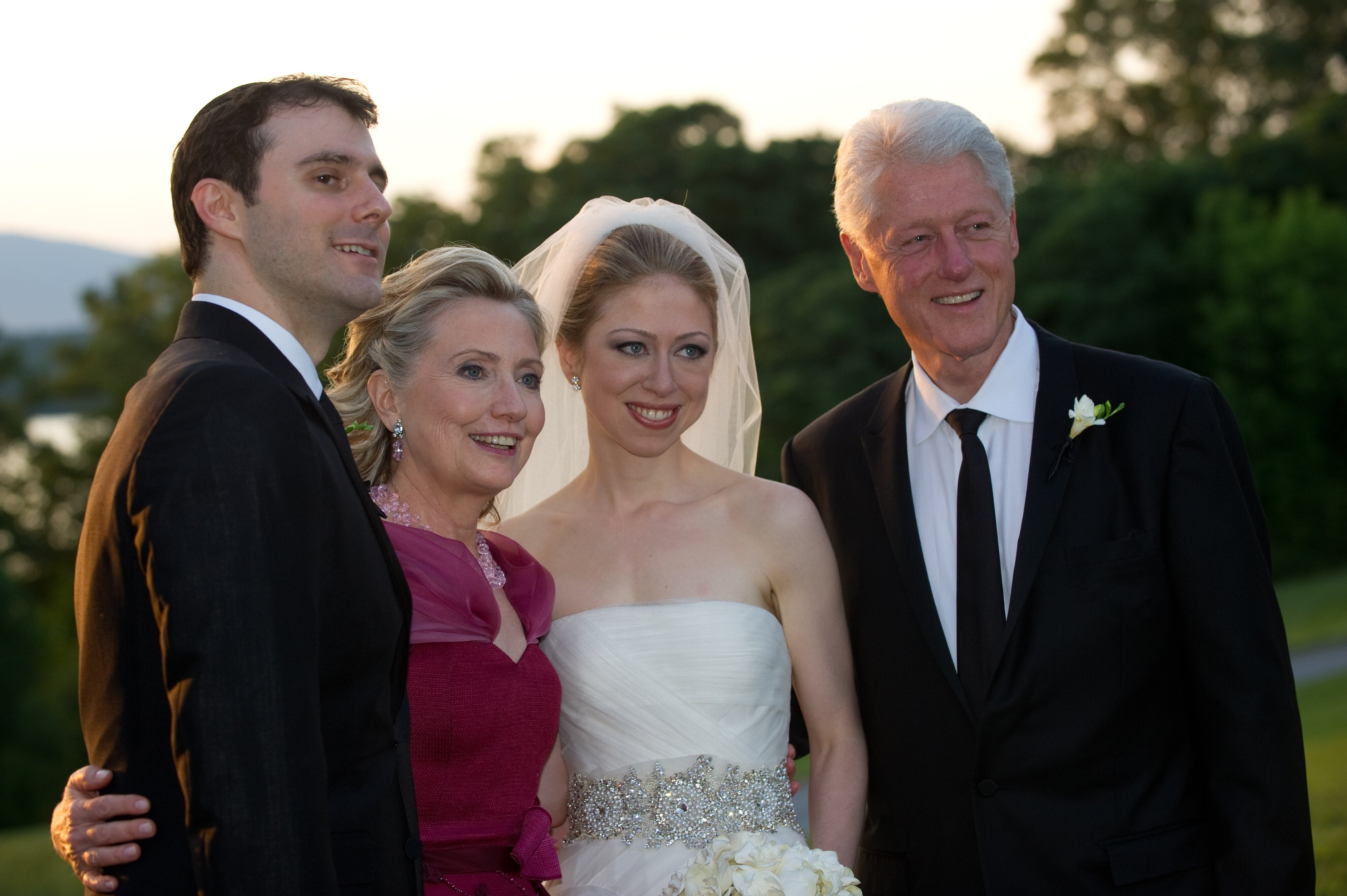 A wedding photograph of a mates with 2 guests. The bride wears a strapless gown, and the guests are dressed successful ceremonial attire