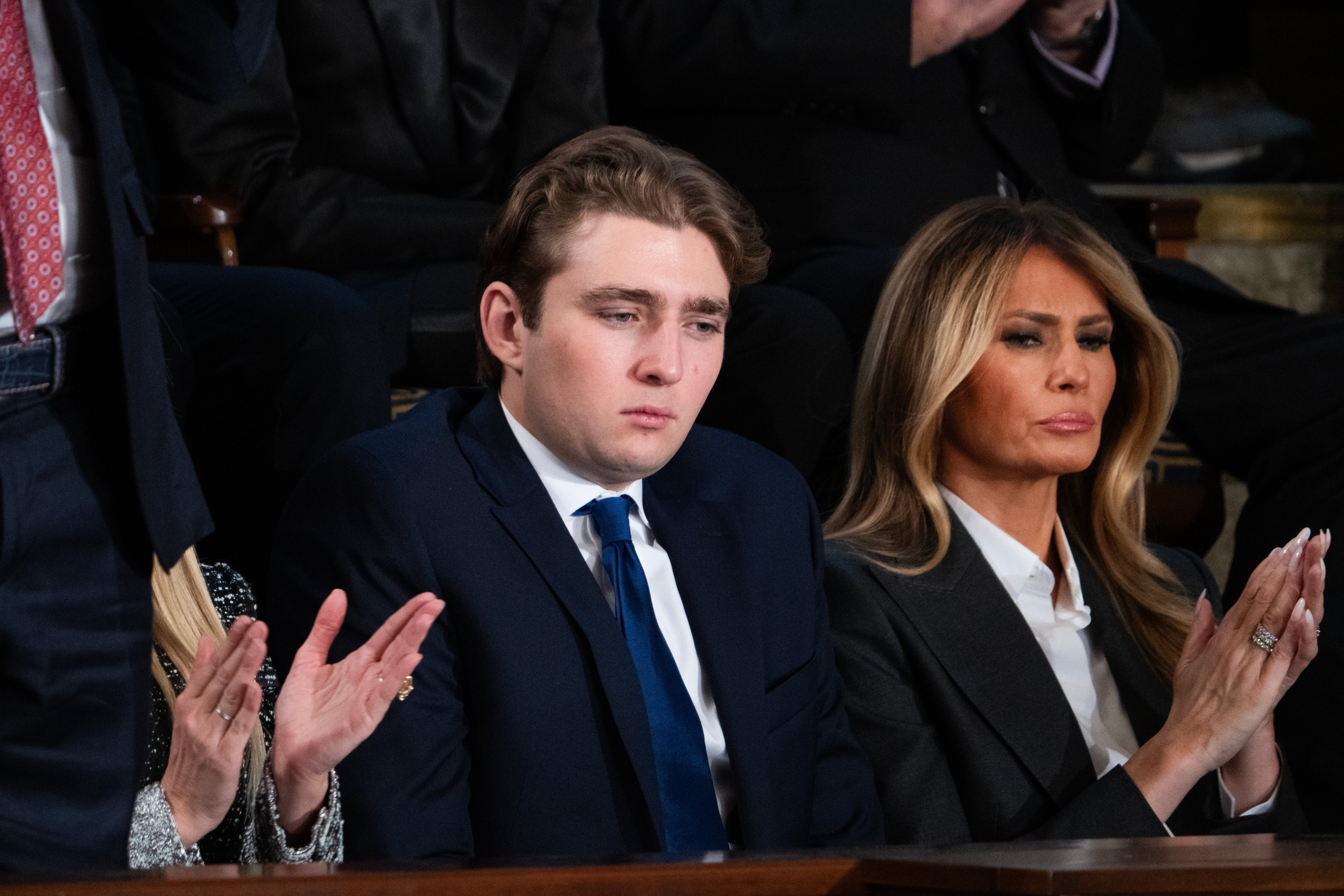 A radical of radical sitting astatine an event, 1 is simply a young antheral successful a suit, beside a pistillate successful a ceremonial blazer